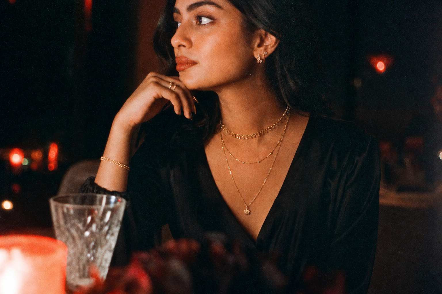 Suri gold jewelry at a candlelit dinner photographed on film