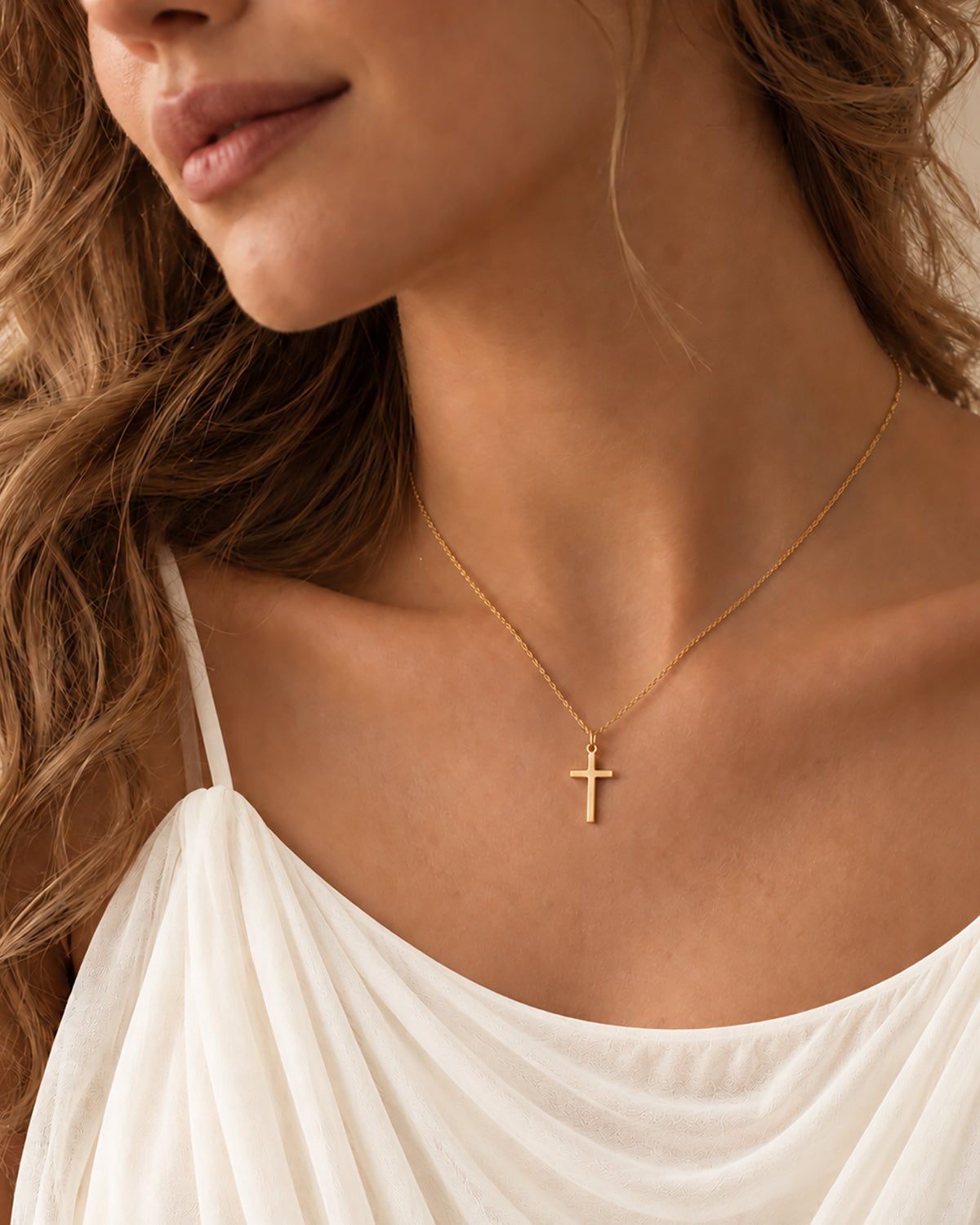 Céleste Cross Necklace in gold worn on model — angled view