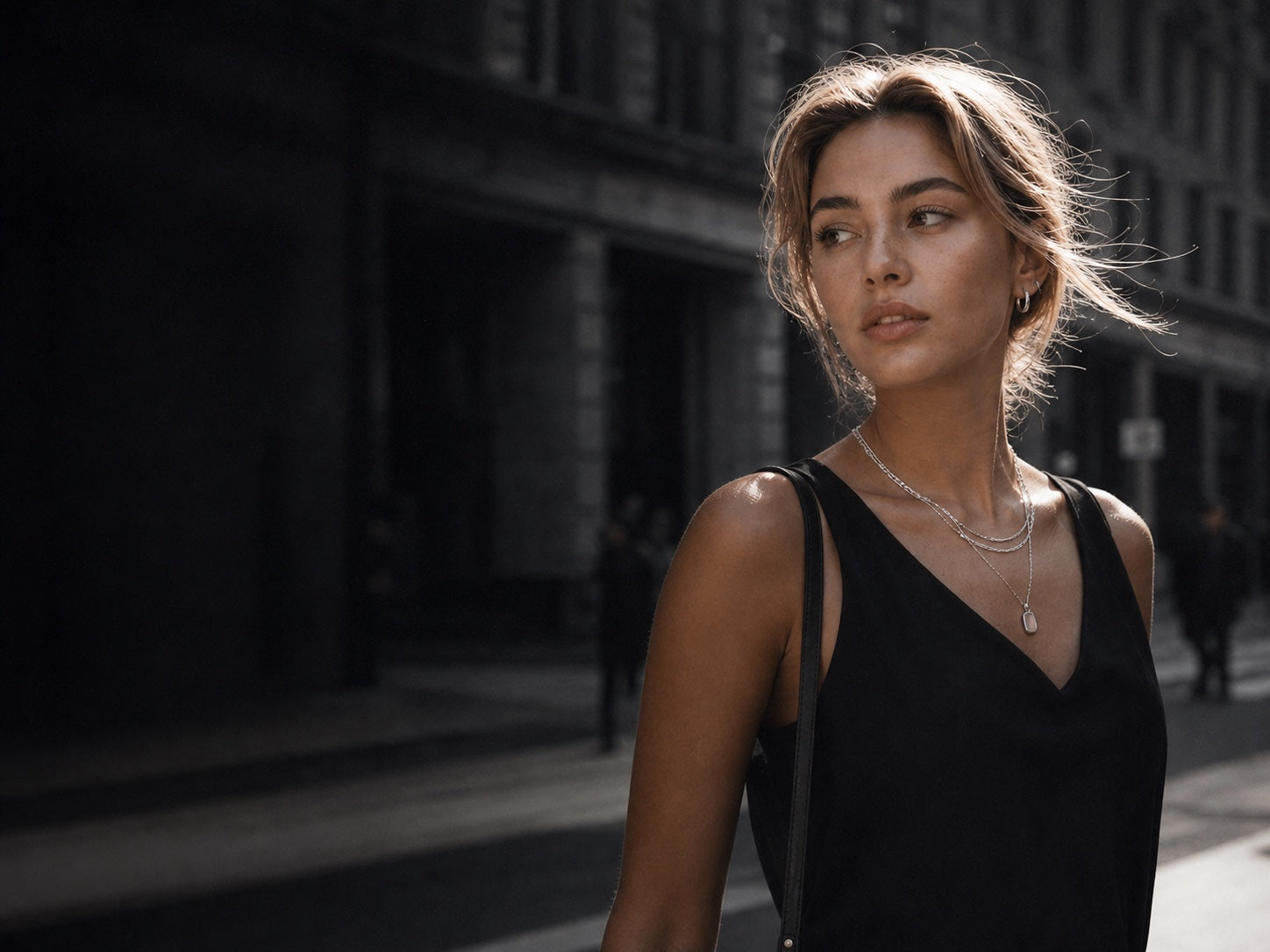 SURI model wearing layered necklaces and hoop earrings