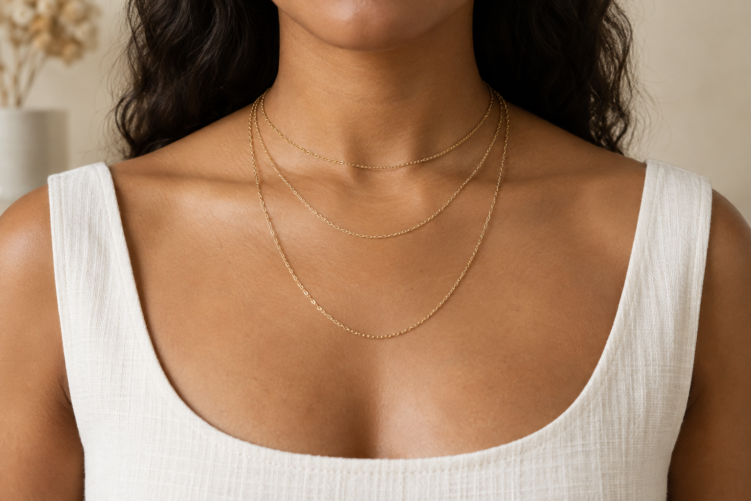 Three gold chains showing progressively lower placement on the neck and chest
